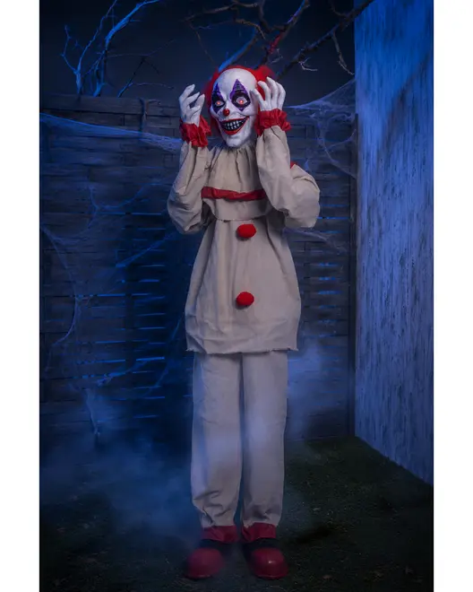 Skrämmande clownkostym med vit dräkt, röda bollar, röda volanger vid ärmar och anklar, stora röda skor och en läskig clownmask med brett leende och röda detaljer.