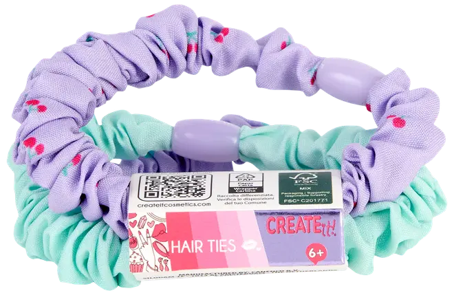 Sæt med to stofhårelastikker: én mintgrøn, én lilla med lyserøde prikker, begge med plastikperler. Velegnet til børn fra 6 år. Leveres med farverig etiket.