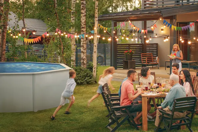 Rund fritstående pool med metalramme og blå inderside. Robuste sidevægge, velegnet til udendørs brug. Perfekt til familiesammenkomster eller fester i haven.