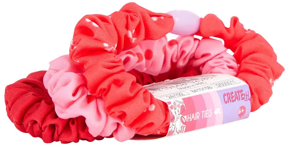 Sæt med tre stof-scrunchies i røde og lyserøde nuancer med prikker, designet til børn fra 6 år. Leveres med mærket papiretikette.