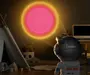 Børnenes natlampeprojektor formet som en astronaut, projicerer en glødende pink og gul sol på væggen. Velegnet til børneværelser, med plysdyr og legetelt synlige.