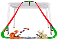 Hot Wheels bilbana med två röda kurvor, dinosaurietema-startare och två leksaksbilar. Fästs på bord för höjd racing och stunts.