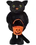 Sort plyskattefigur med gule øjne, orange næse og Halloween-græskarbøtte, stående på store fødder med lang hale.