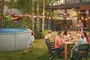 Rund fritstående pool med solide metalsider, fyldt med vand. Velegnet til udendørs brug, perfekt til familiesammenkomster eller fester. Enkel, moderne stil passer til haven.
