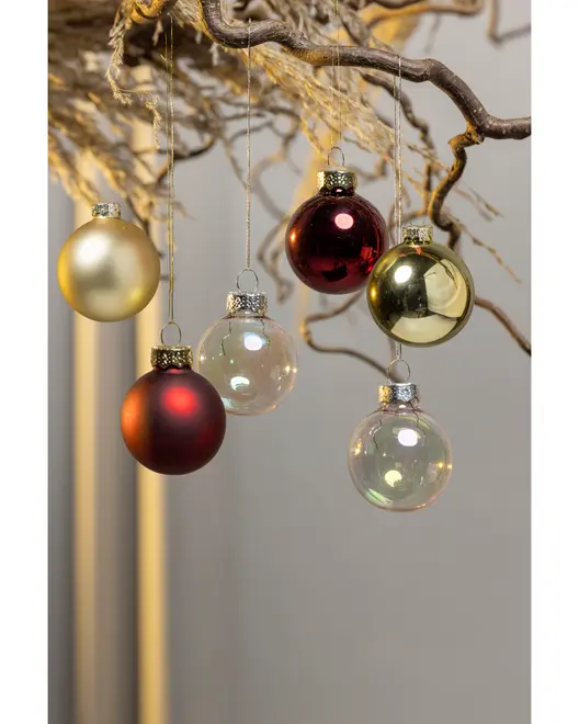 Set med sex julgranskulor i guld, rött och klart glas, hängande från en gren. Varje kula har metallock och snöre för upphängning.