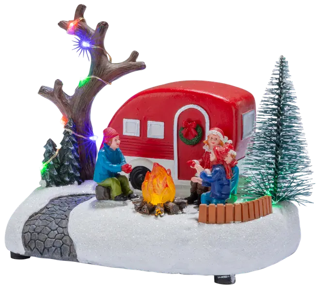 Juleborddekoration med rød campingvogn, to figurer ved lejrbål, sneklædt base, lysende træ og miniaturegrantræer.