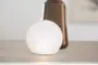 Rund vit LED-bordslampa med textur, ger mjukt omgivande ljus. Modern design, kompakt storlek, energisnål, dekorativ detalj för vardagsrum eller sovrum.