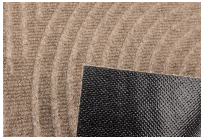 Närbild av beige matta med böjda linjer och svart halkfri gummibaksida för säker placering på golv.