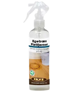 Klar sprayflaske med FAXE Egetræ Pletfjerner, fjerner misfarvninger på egetræ. Udstyret med sprayhoved og etiket med illustration af anvendelse på træbord.