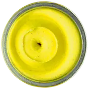 Topbillede af et glas fyldt med lys gul, cremet body butter eller lotion med en glat, pisket tekstur og let hvirvelmønster på overfladen.