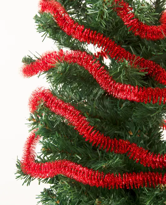 Kunstigt juletræ med grønne grene, pyntet med en skinnende rød guirlande snoet rundt i spiral. Festlig og velegnet til juleudsmykning.