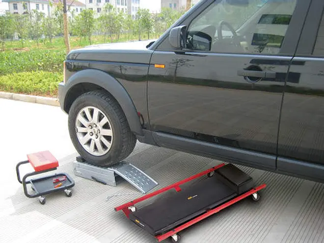 Bilservicepaket med vadderad liggbräda, rullstol och metallramp, perfekt för underhåll och arbete under bilen.