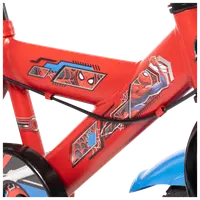 Närbild på röd barncykelram med färgglada Spider-Man-motiv, inklusive Spider-Mans ansikte och actionpose, svart kabel och blå detalj på hjulet.