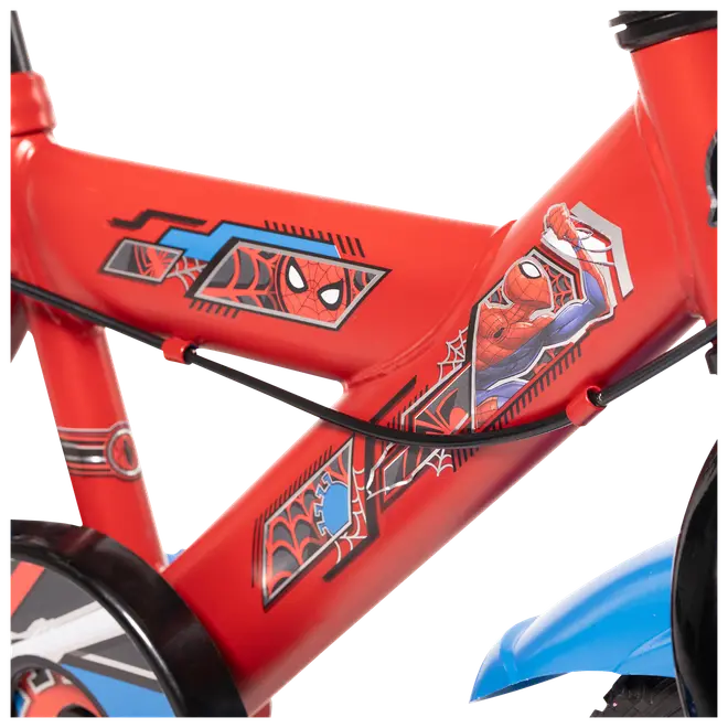 Närbild på röd barncykelram med färgglada Spider-Man-motiv, inklusive Spider-Mans ansikte och actionpose, svart kabel och blå detalj på hjulet.