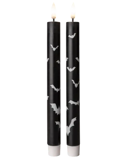 Två svarta LED-stearinljus med vita fladdermusmotiv. Flamlösa, batteridrivna, perfekta för Halloween eller temadekor. Realistisk flimrande ljuseffekt.