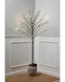 Tall decorative tree with slender black branches, each tipped with small warm white LED lights. The tree is placed in a textured, light gray pot filled with pinecones. The design is minimalist and modern, suitable for indoor use as accent lighting or seasonal decoration.
