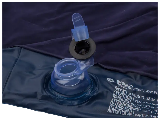 Närbild av luftmadrassventil med öppen blå plastkåpa, visar uppblåsningsport och varningstext tryckt på mörkblå vinyl.