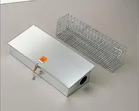 Metalfælde til dyr med aflåselig boks og trådbur. Boksen har biohazard-mærkat, nøglelås og rundt indgangshul i den ene ende.