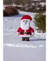 Julemandsfigur i rød dragt og hat med hvidt skæg, sort bælte og støvler, stående udendørs i sne.