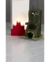 Miniatyr grøn trægyngestol med hjerteformet udskæring og hvide detaljer, vist ved siden af en rød trinformet lysestage med tændte lys.