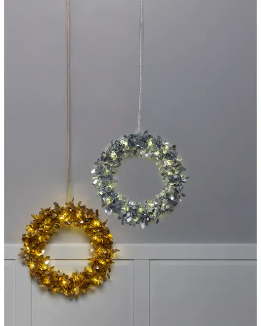 Sæt med to dekorative kranse, én i guld og én i sølv, begge med integrerede LED-lys. Kranse med metallisk bladdesign og ophængt i matchende bånd.