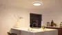 Moderne rund loftslampe med slank sort ramme, fladmonteret design, udsender blødt hvidt lys, velegnet til køkken eller stue, energieffektiv LED, minimalistisk og nutidig stil.