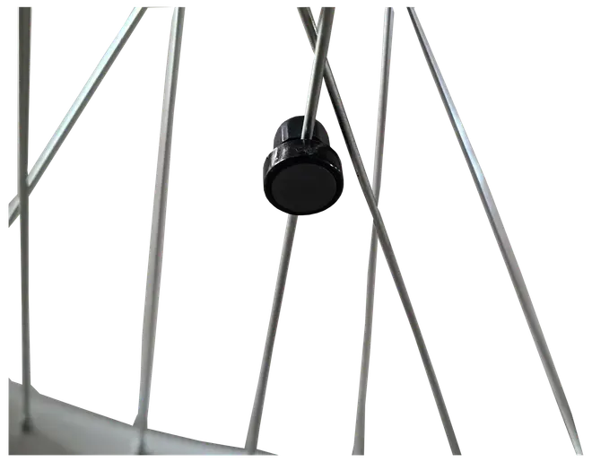 Nærbillede af et cykelhjul med metal-eget og en sort plastik-egetmagnet til cykelcomputer eller speedometer.