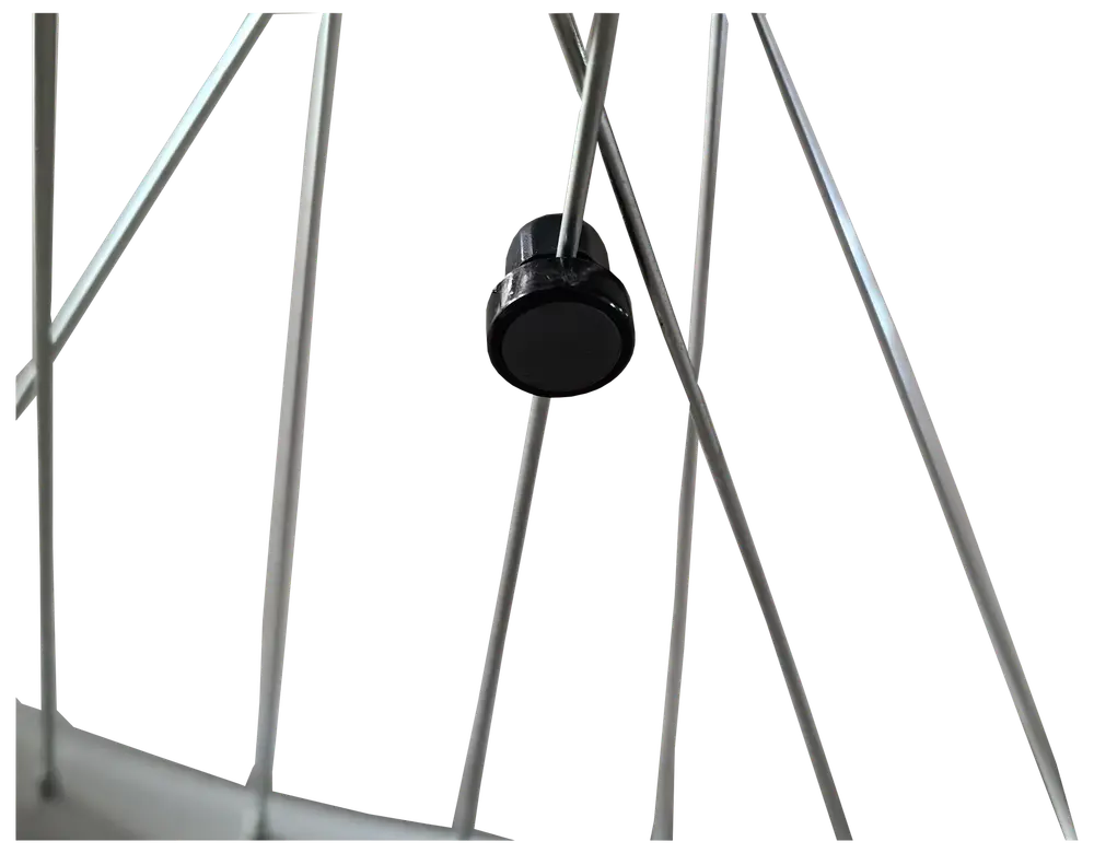 Nærbillede af et cykelhjul med metal-eget og en sort plastik-egetmagnet til cykelcomputer eller speedometer.