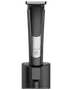 Sladdlös elektrisk hårtrimmer med digital display, räfflat grepp, rostfria stålblad och strömknapp. Står upprätt i svart laddningsställ. Passar för skägg- och hårvård.