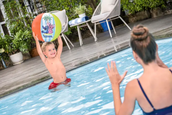Farverig oppustelig strandbold med Stitch-motiv, orange, grønne og hvide felter. Perfekt til pool eller strand, let og nem at håndtere for børn.
