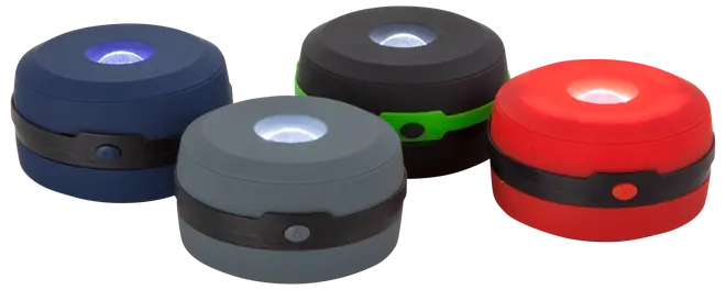 Sæt med fire kompakte, runde LED campinglanterner i blå, sort, grå og rød. Hver har centralt lys, sort bånd med knap og robust plastkonstruktion.