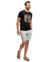 Herrset med svart t-shirt med texten “Kingshill Polo Club” och ljusgrå shorts med “Polo Club” på benet. Modellen bär bruna sandaler. Ansiktet är suddigt.