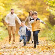 Børns efterårsoutfit: gul vatteret vest, grå hættetrøje, marineblå bukser og sneakers. Perfekt til udendørs leg, varm og behagelig til efteråret, slidstærk og let at kombinere.