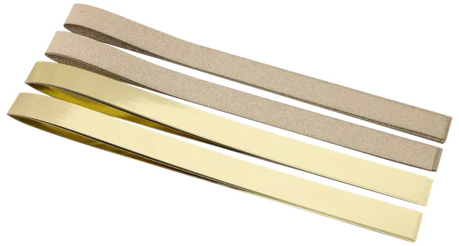 Sæt med fire slibebånd, to med grov brun slibeflade og to med glat gylden metalfinish, velegnet til slibning eller polering af værktøj og knive.