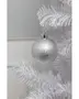 Sølvfarvet julekugle med frostet, tekstureret overflade, hængende på en hvid kunstig gren. Klassisk rund form, metalophæng, perfekt til juleudsmykning.