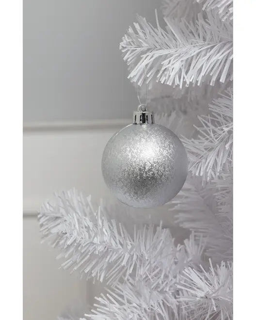 Sølvfarvet julekugle med frostet, tekstureret overflade, hængende på en hvid kunstig gren. Klassisk rund form, metalophæng, perfekt til juleudsmykning.
