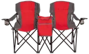 Dobbelt foldbar campingstol i rød og grå, med indbyggede kopholdere i armlæn og en central køletaske. Let og bærbar, ideel til udendørs brug.