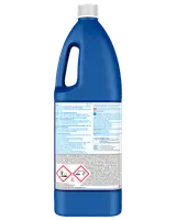 Stor blå plastflaske med blegemiddel, hvidt låg og ergonomisk håndtag. Bagsideetiketten viser brugsanvisning og advarsler, herunder faresymboler for miljø- og sundhedsrisici.