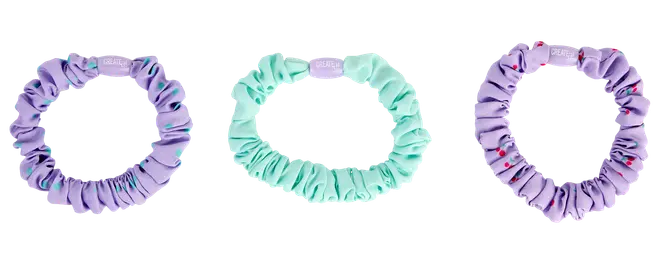 Sæt med tre elastikker: to lilla og én mintgrøn. Alle er lavet af glat, rynket stof, hvoraf den ene lilla har små farvede prikker som dekoration.