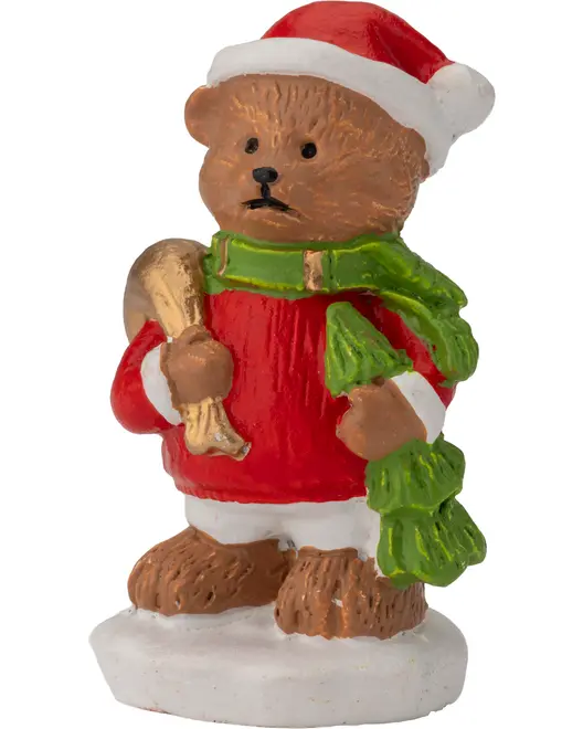 Julebjørn-figur med rød nissehue, rød frakke, grøn tørklæde og holder et gyldent horn. Står på hvid base. Lavet af malet keramik eller resin.