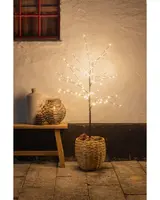 Konstgjort träd med LED-lampor på nakna grenar, placerat i en flätad korgkruka. Passar för dekorativ belysning inomhus eller utomhus, ger mysig stämning.