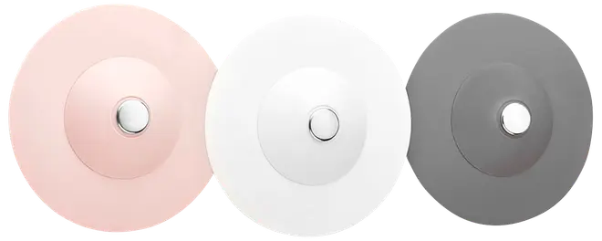 Tre runda, skivformade enheter i rosa, vitt och grått, var och en med en centrerad metallknapp.