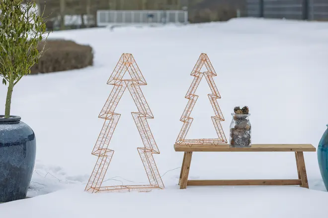 To kobberfarvede trådtræer i forskellige størrelser med geometrisk zigzag-design og åben metalramme.