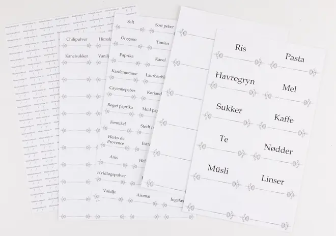 Sæt med hvide køkkenlabels med sort tekst til glas og beholdere, inklusive ris, pasta, havregryn, mel, sukker, kaffe, te, nødder, müsli og linser.