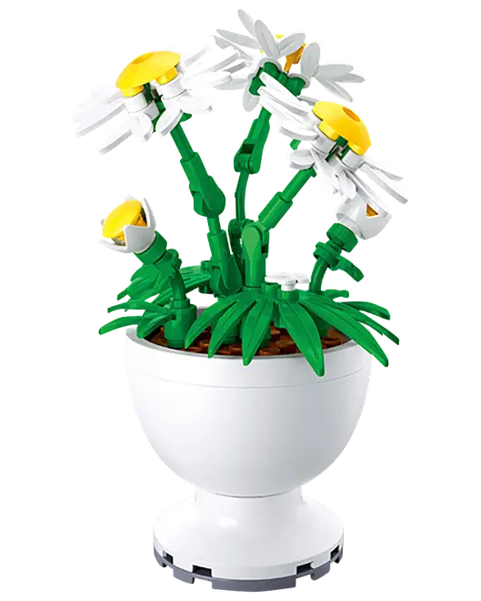 Vita prästkrageliknande blommor med gula mittpartier i en vit dekorativ kruka, byggd av klossar med gröna stjälkar och blad.