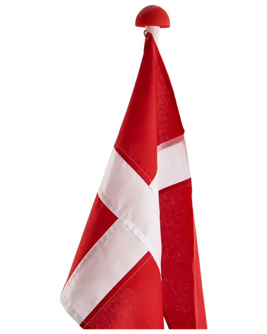 Bordflag med Dannebrog, rød baggrund og hvidt kors, monteret på stang med rød knop. Fremstillet i stof, ideel til festlige lejligheder eller dekoration.
