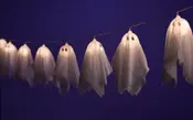 Girlang med spökformade Halloween-lampor, varje spöke av vitt tyg med svarta ögon, hängande på en tråd. Mjukt sken, passar för inomhusdekoration.