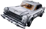 Sølvfarvet legetøjsbil i vintage-stil med runde forlygter, kromdetaljer, sort grill, beige interiør og en minifigur som fører.
