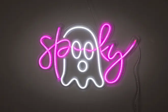 Neonskylt med vit spökfigur och ordet 'spooky' i ljusrosa kursiv. Väggmonterad, elansluten, perfekt för Halloween eller temadekor.