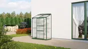 Litet väggmonterat växthus med grön metallram och klara paneler, enkel dörr och lutande tak. Perfekt för uteplatser eller små trädgårdar, platsbesparande odling.
